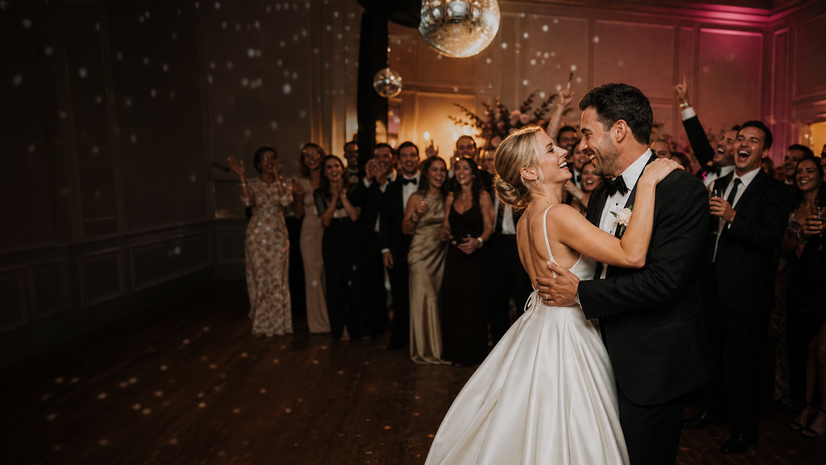 Newly married couple dancing while wedding guests celebrate around them